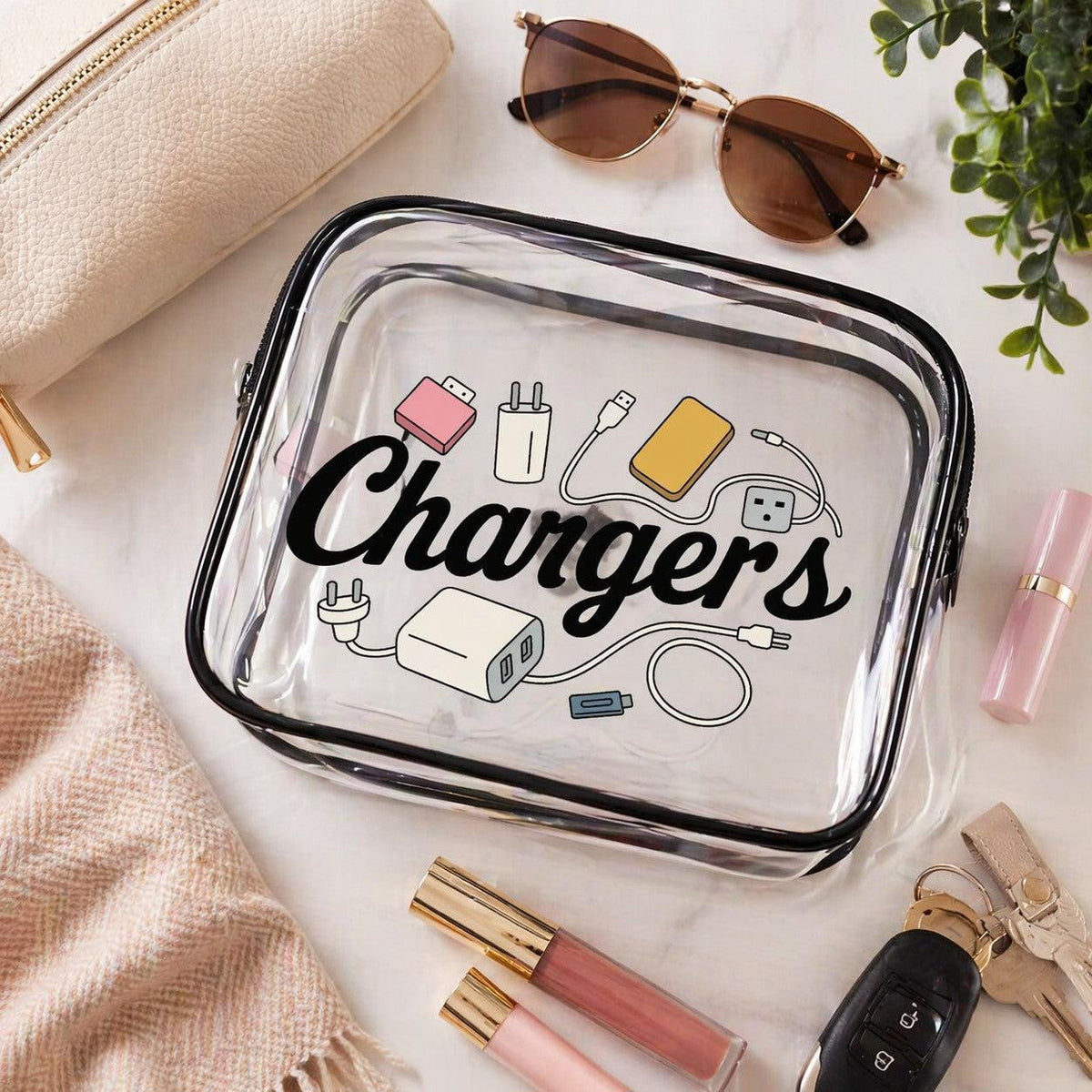 Clear travel case with 'Chargers' text and icons on a marble surface with accessories.