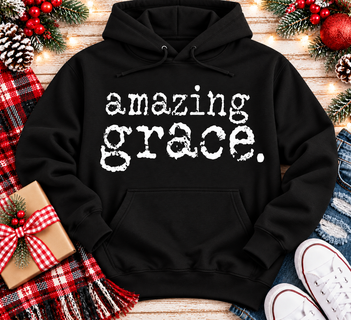 A black pullover hoodie with the words 'amazing grace.' printed in a distressed white typewriter-style font across the chest.