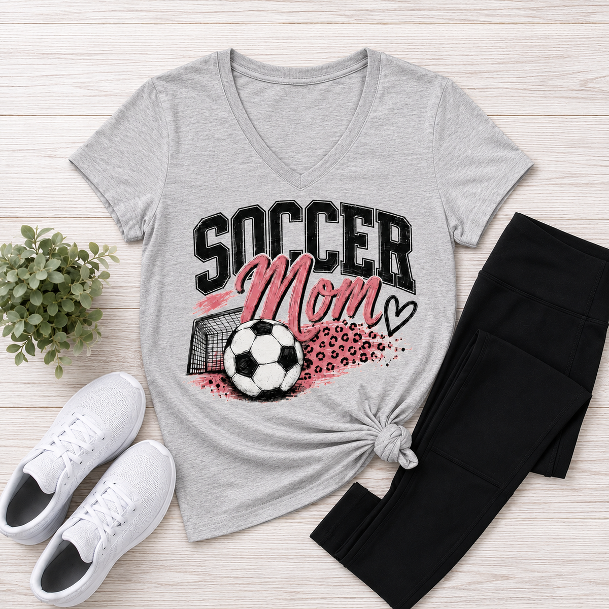 Gray V-neck Soccer Mom graphic tee with pink and black soccer ball, goal and leopard print design.