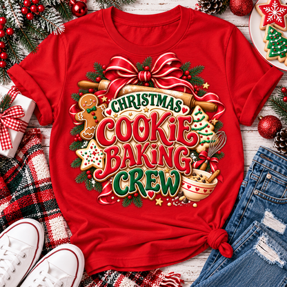 Christmas Cookie Baking Crew holiday graphic apparel featuring festive red and green lettering, gingerbread cookies, rolling pin, mixing bowl, Christmas greenery and red bow. Available in red, black and sand in four styles: crewneck tee, V-neck tee, sweatshirt and hoodie.