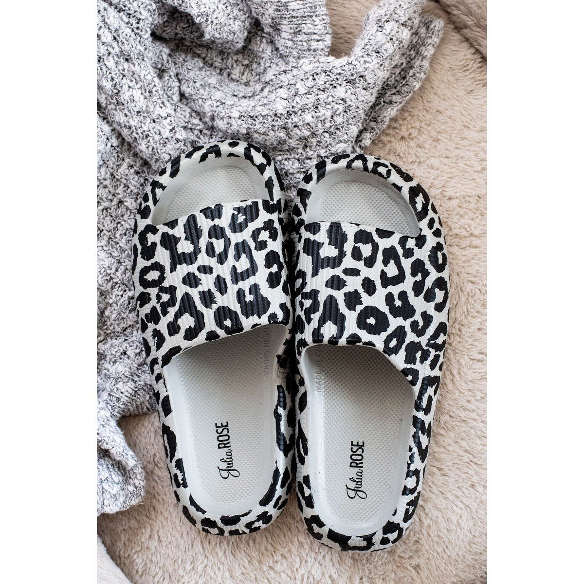 Gray leopard-print beach slides with a bold spotted pattern and easy slip-on design.