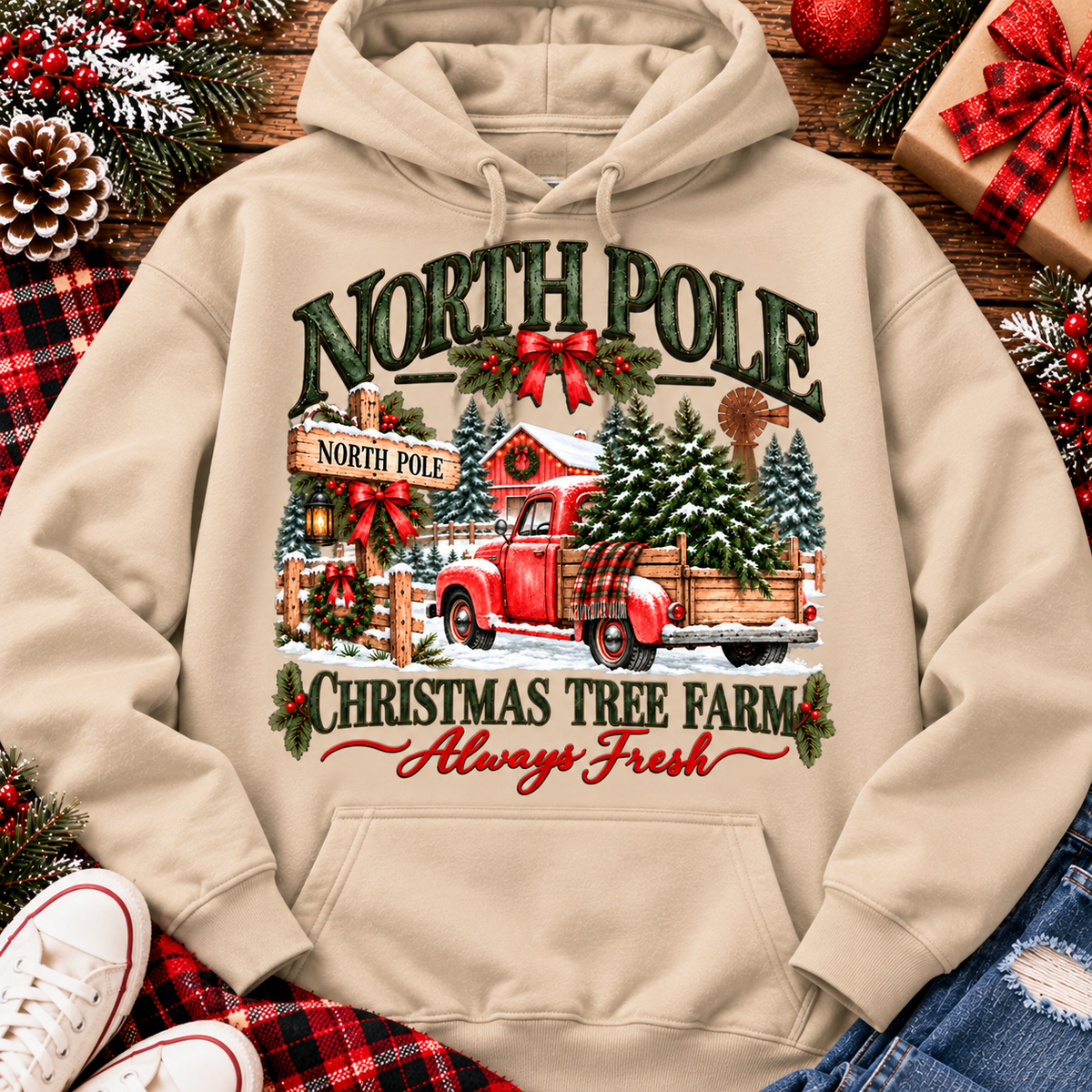 North Pole Christmas Tree Farm vintage holiday graphic shirt featuring a red pickup truck carrying Christmas trees, snowy evergreen trees, rustic farmhouse scenery, festive red bows, and distressed green lettering reading North Pole Christmas Tree Farm Always Fresh. Available in beige and black in short sleeve crewneck, V-neck, long sleeve crewneck, and hoodie styles.