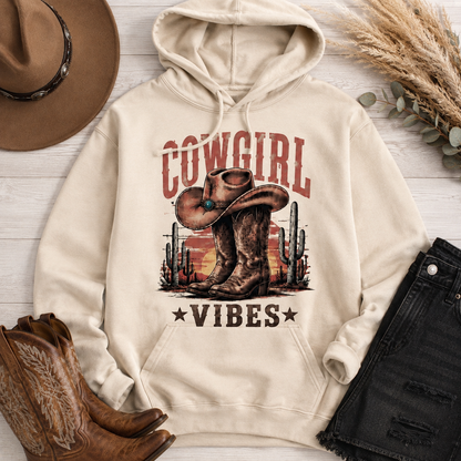 Cowgirl Vibes western graphic apparel featuring cowboy boots, cowgirl hat, cacti and desert sunset design