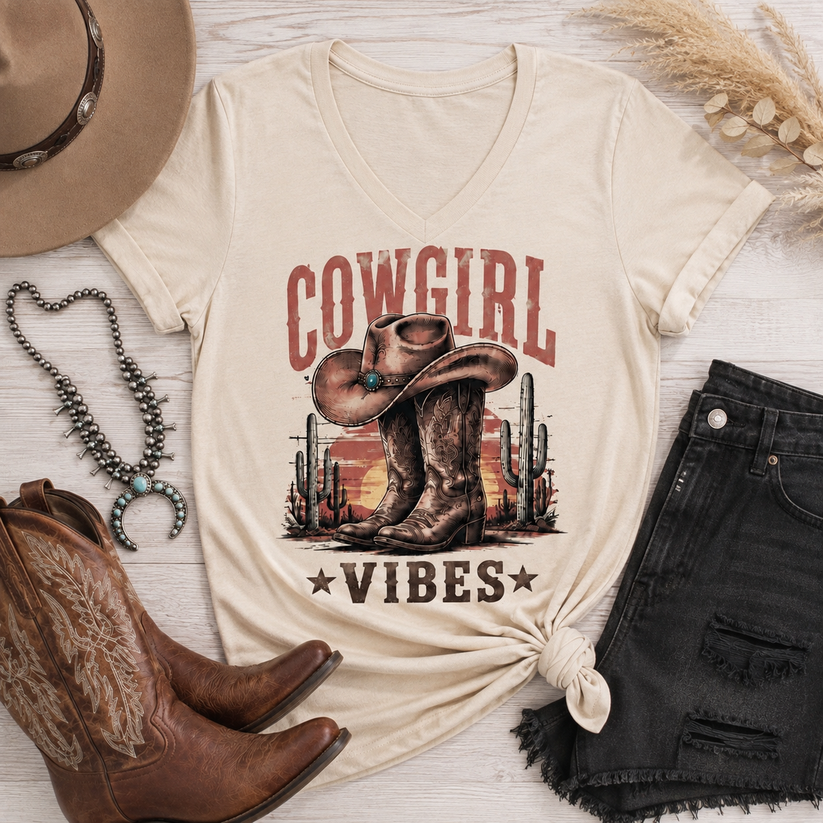 Cowgirl Vibes western graphic apparel featuring cowboy boots, cowgirl hat, cacti and desert sunset design
